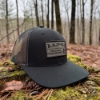Lund Camo Hat sitting on moss stump in woods