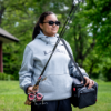 Woman carrying fishing gear wearing the Lund AFTCO Reaper hoodie